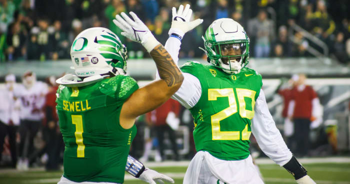 Adrian Jackson (29) high-fives Noah Sewell (1) in a game against Washington State at Autzen Stadium.